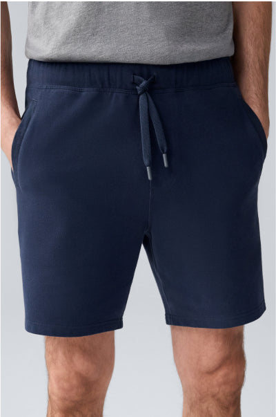 Navy shorts worn by a person on a light gray background