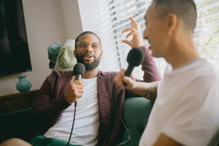2 guys talking into microphones